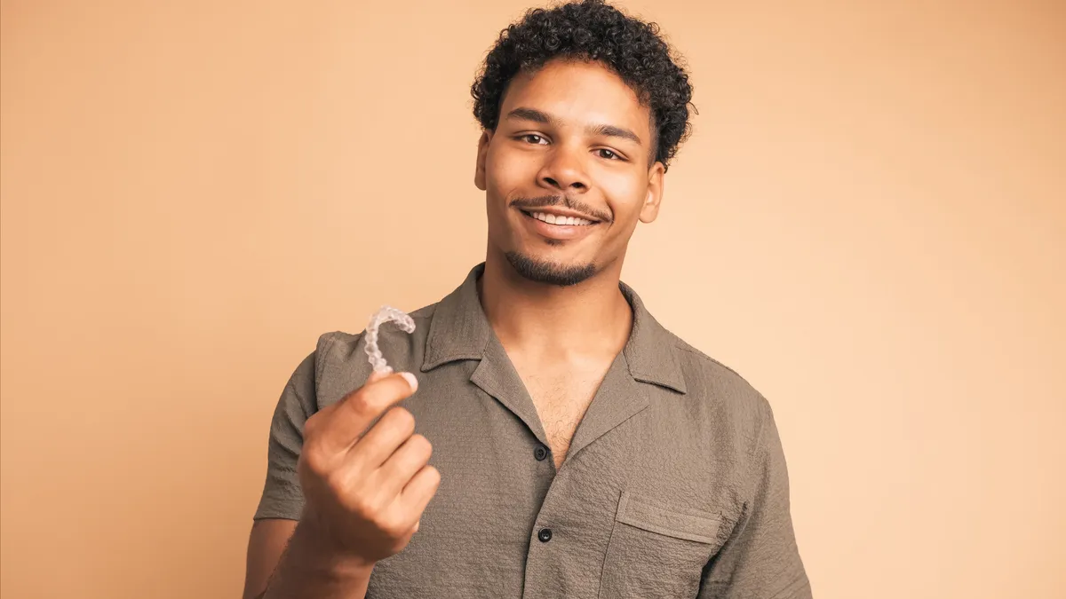 A patient holding their clear aligner