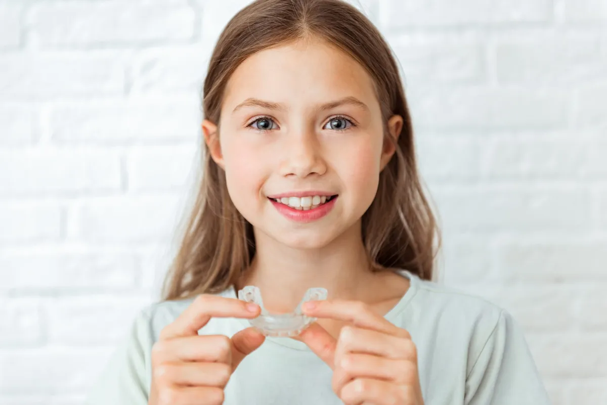 A child with a backpack smiling at home before school