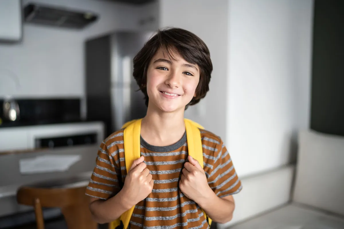 A young patient holding a clear aligner