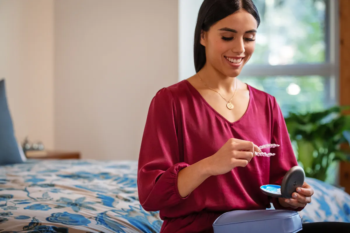 A patient placing her Invisalign® aligner back in its case