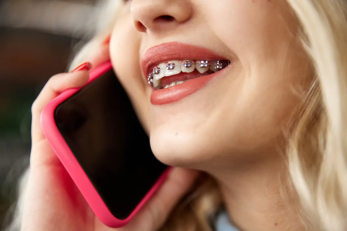 A confident young person smiling with braces