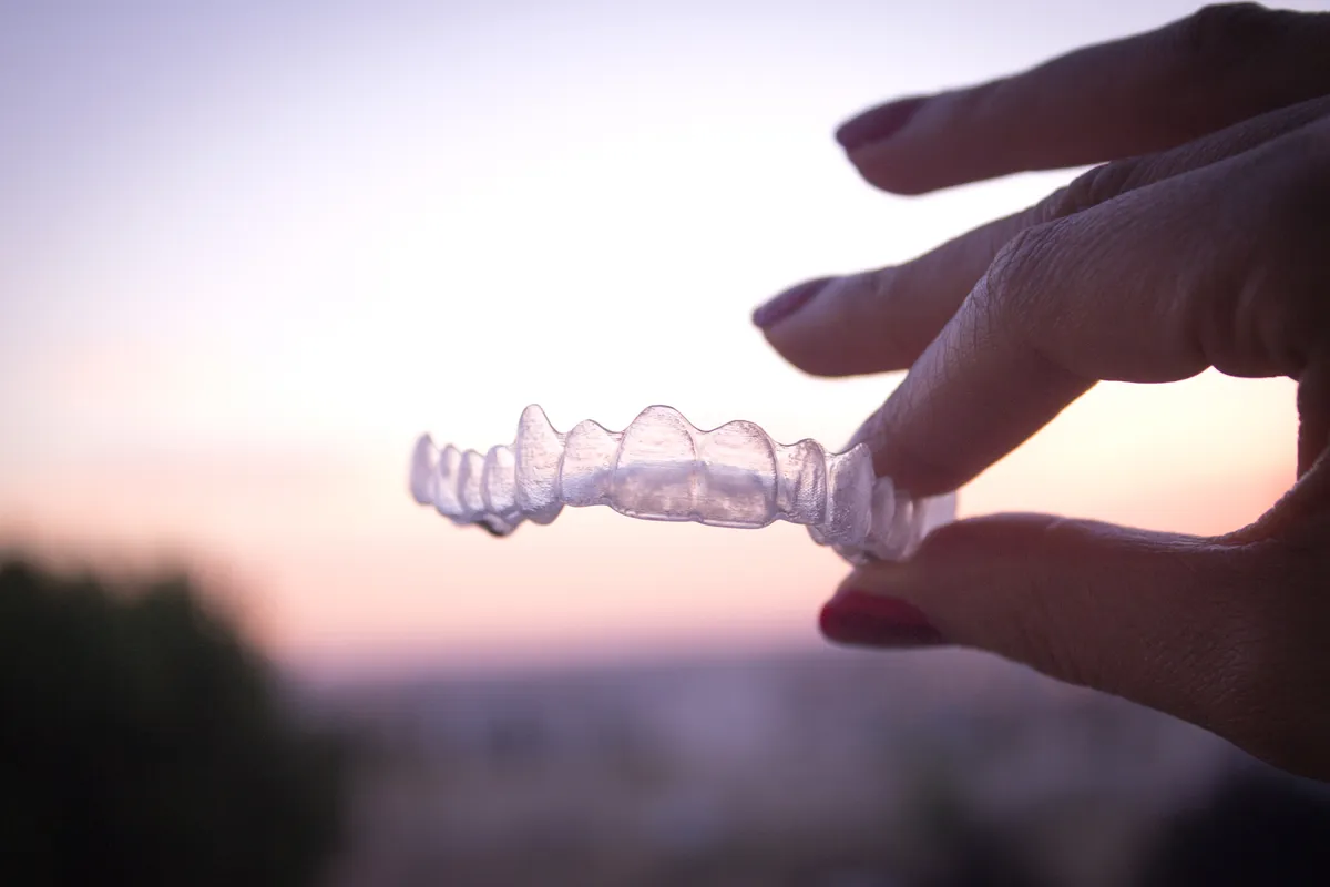 A patient holding a clear retainer